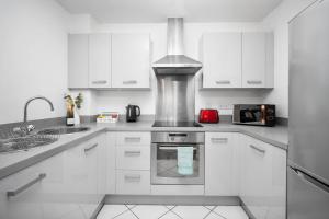 a kitchen with white cabinets and a stove top oven at Large City Centre Apartment - Balcony - Free Wifi & Netflix 85S in Birmingham