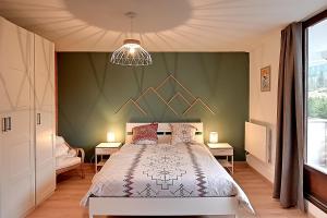 - une chambre avec un lit et un mur vert dans l'établissement Moho des Oursons - Pistes de ski à 450m, à La Bresse