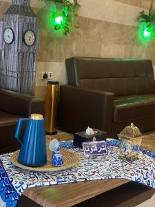 a table with a table cloth on a table with a clock at نجوم طابة الطيبة للشقق المخدومة in Al Jāmi‘ah