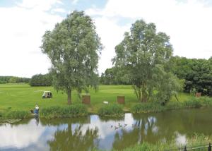 a person standing next to a pond in a park at Old Nene Golf And Country Club in Upwood