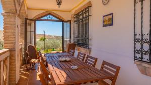 a room with a wooden table and chairs on a balcony at Casa Rural Cayara by Ruralidays in Villanueva de la Concepción