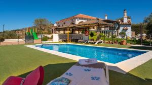 a villa with a swimming pool in front of a house at Casa Rural Cayara by Ruralidays in Villanueva de la Concepción
