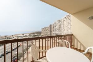 a balcony with a table and chairs and a view of a city at Estudio WELCS EMP-124- con vistas al mar in Empuriabrava