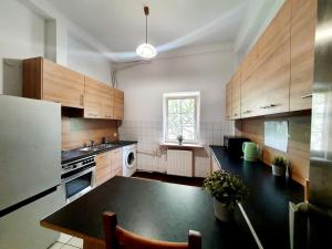 a kitchen with wooden cabinets and a black counter top at Tanie pokoje w centrum in Sopot