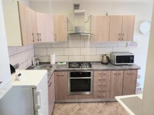 a kitchen with a stove and a microwave at Apartament w Centrum in Duszniki Zdrój