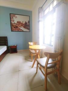une chambre avec une table, des chaises et une fenêtre dans l'établissement Dong Nguyen Riverside Homestay, à Hội An