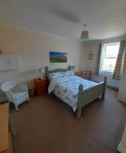 a bedroom with a bed and a chair at Mark cottage in Creetown