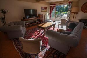ein Wohnzimmer mit Sofas und einem TV in der Unterkunft Demeure du Haut Canteloup in Honfleur