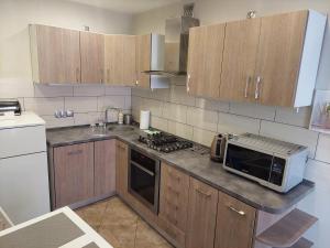 a kitchen with wooden cabinets and a microwave on a counter at Apartament w Centrum in Duszniki Zdrój