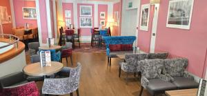 a restaurant with tables and chairs in a room at The Empress Hotel in Douglas