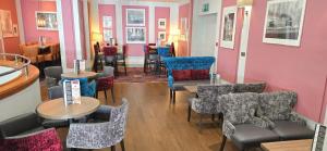 un restaurante con mesas y sillas en una habitación en The Empress Hotel, en Douglas