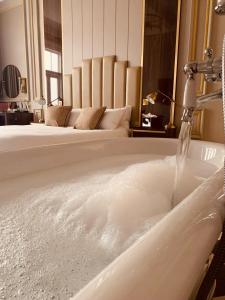 a bath tub filled with water next to a bed at Edgbaston House in Birmingham