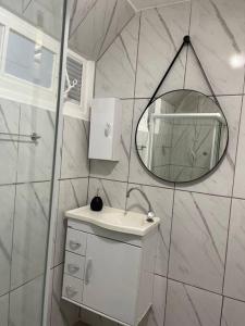 Baño blanco con lavabo y espejo en Apartamento Moderno Centro RJ, en Río de Janeiro