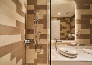 ein Bad mit einem Waschbecken und einer Dusche in der Unterkunft First Class Apartments in Seven Palm with direct Access to the West Palm Beach and Nakheel Mall in Dubai