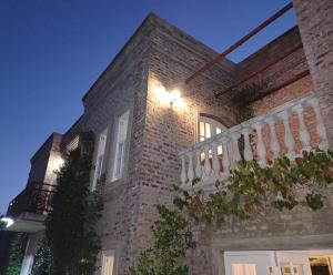 a brick building with a balcony with lights on it at Villa Anna Katarina in Riebeek-Kasteel