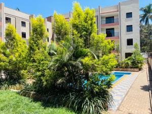 un edificio de apartamentos con piscina y árboles en Julie Heights Apartments en Kampala