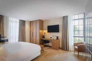 um quarto de hotel com uma cama, uma secretária e uma televisão em Hotel & Spa Convento San Francisco em Soria