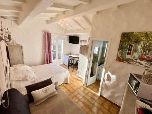 a bedroom with a white bed and a desk at Bastide du Levant in Sainte-Maxime