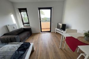 - un salon avec un canapé et une télévision dans l'établissement Schönes Apartment mit Balkon in Mannheim Nahe Rheinauer See, à Mannheim