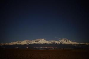 una montaña cubierta de nieve en la distancia por la noche en Apartman Family, en Poprad