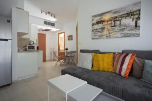 ein Wohnzimmer mit einem Sofa und einer Küche in der Unterkunft 2BD and 2 Bath duplex on the Hilton beach in Tel Aviv
