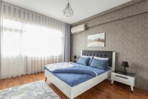 een slaapkamer met een blauw bed en een raam bij Nişantaşı Ana Cadde Üzeri Aydınlık Büyük Daire in Istanbul