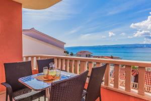 un tavolo su un balcone con vista sull'oceano di Sunsee Apartments a Duće