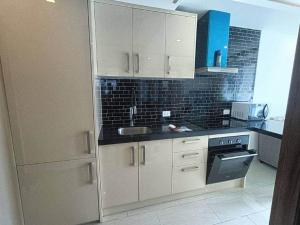a kitchen with white cabinets and a sink at 2 Beds 2 Baths Apartment in Pattaya in Pattaya Central
