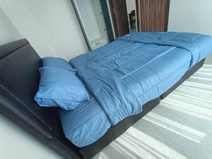 a bed with a blue comforter in a bedroom at 2 Beds 2 Baths Apartment in Pattaya in Pattaya Central
