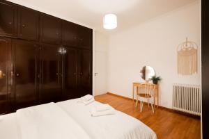 a bedroom with a large white bed and a table at Central Kolonaki flat B - Greecing in Athens