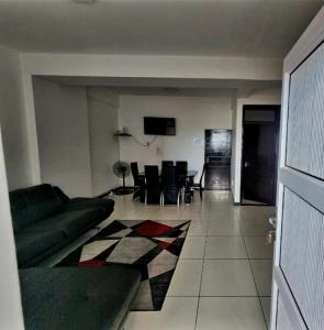 a living room with a couch and a table and chairs at Beachurst Apartment in Durban