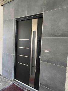 eine schwarze Tür an einer Wand mit einem Spiegel in der Unterkunft Entire Flat for you Schwetzingen,Mannheim & HD in Oftersheim