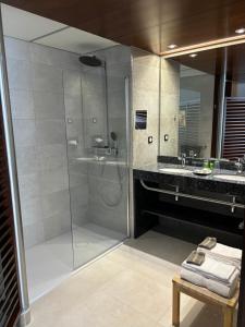 W łazience znajduje się prysznic ze szklanymi drzwiami. w obiekcie Hotel Le Grand Pavois w mieście Fécamp