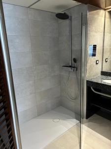 a shower with a glass door in a bathroom at Hotel Le Grand Pavois in Fécamp