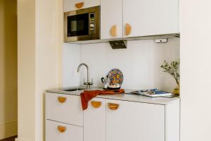 eine Küche mit einer Spüle und einer Mikrowelle in der Unterkunft Mason & Fifth, Primrose Hill in London