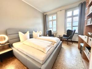 1 Schlafzimmer mit einem Bett und 2 Stühlen in der Unterkunft Ferienwohnung an der Schelfkirche in Schwerin