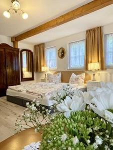 1 dormitorio con 2 camas y flores en una mesa en Ferienheim Kuckuckswinkel - Familiensuite, en Schöna