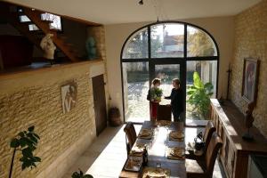 two people standing at a table in a room at La maison d'art et d'hôtes in Leuglay