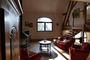 a living room with red couches and a table at La maison d'art et d'hôtes in Leuglay