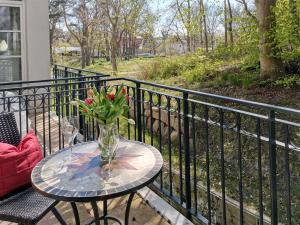 a table with a vase of flowers on a balcony at Haus Meeresblick - Ferienwohnung Sandrose A 2.26 (Ref. 132363) in Baabe