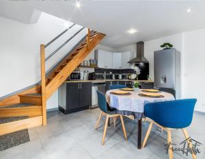 a kitchen and dining room with a table and blue chairs at Magny's Oasis - DisneyLand 5min - Private Parking - Terrace & Garden in Magny-le-Hongre +16 photos