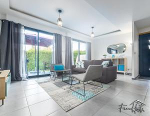 a living room with a couch and chairs and windows at Magny's Oasis - DisneyLand 5min - Private Parking - Terrace & Garden in Magny-le-Hongre