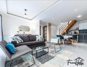 a living room with a couch and a table at Magny's Oasis - DisneyLand 5min - Private Parking - Terrace & Garden in Magny-le-Hongre