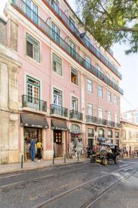 リスボンにあるLD Apartments Alfamaの通路側のピンクの建物