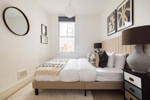 a bedroom with a bed with a mirror on the wall at The Brockwell Park Place - Bright 2BDR Flat in London