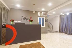 a lobby with a counter with a c brief sign on the wall at Super OYO Collection O RCC Pristine in Hyderabad