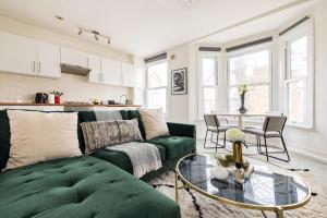 a living room with a green couch and a table at The Brockwell Park Place - Bright 2BDR Flat in London