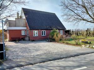 een rood huis met een zwart dak bij Oestermark in Ærøskøbing
