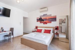 a bedroom with a large bed with red pillows at 360 GuestHouse - Apartment with terrace in Fiumicino +8 photos