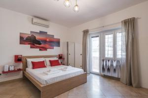 a bedroom with a large bed with red pillows at 360 GuestHouse - Apartment with terrace in Fiumicino